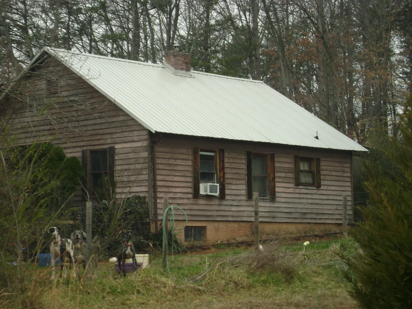 White metal roof on an old wood sided farmhouse, from a Metal Roof Installation job in Medina